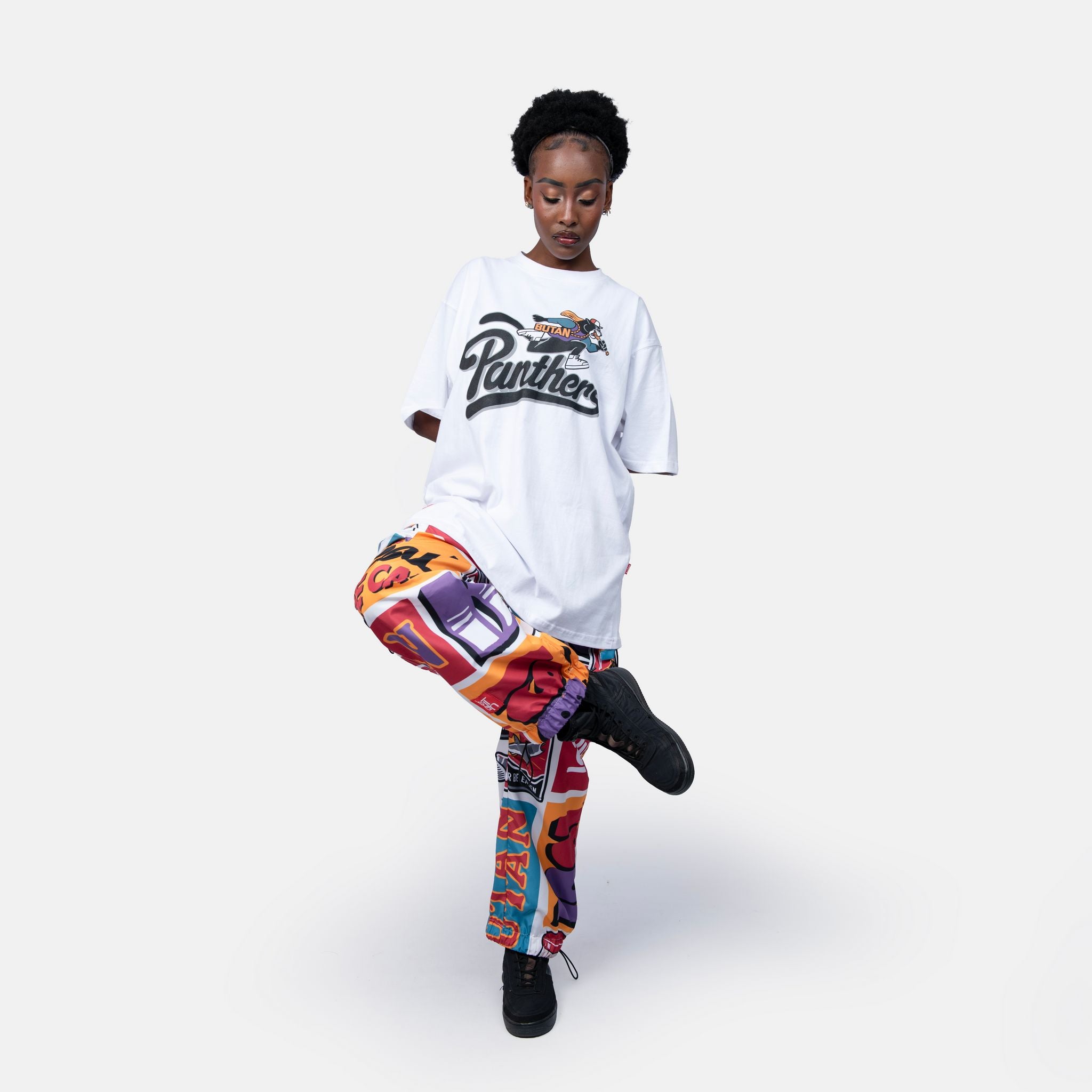 Person wearing a white t-shirt and colorful pants on a white background