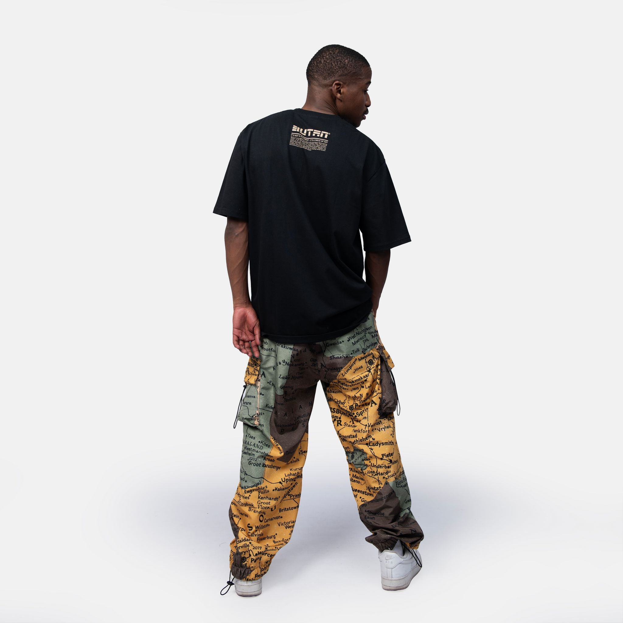 Person wearing a black t-shirt and camouflage pants on a white background