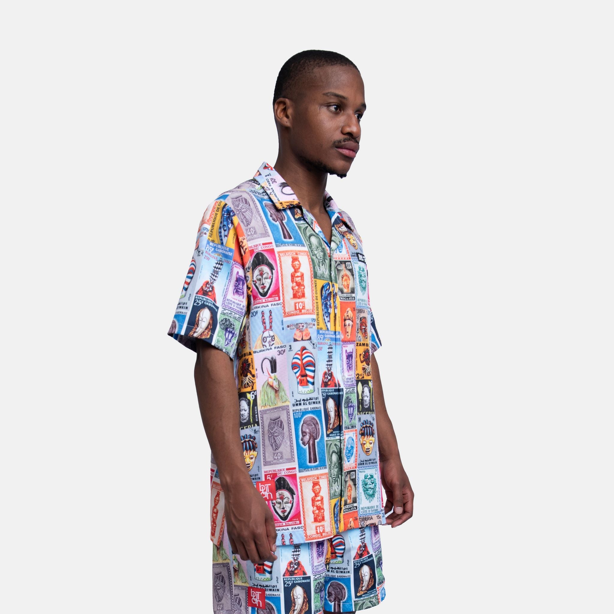 Man wearing a colorful patterned shirt on a white background