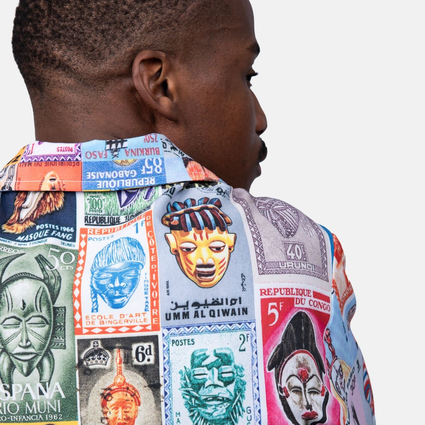 Person wearing a colorful shirt with various designs and text