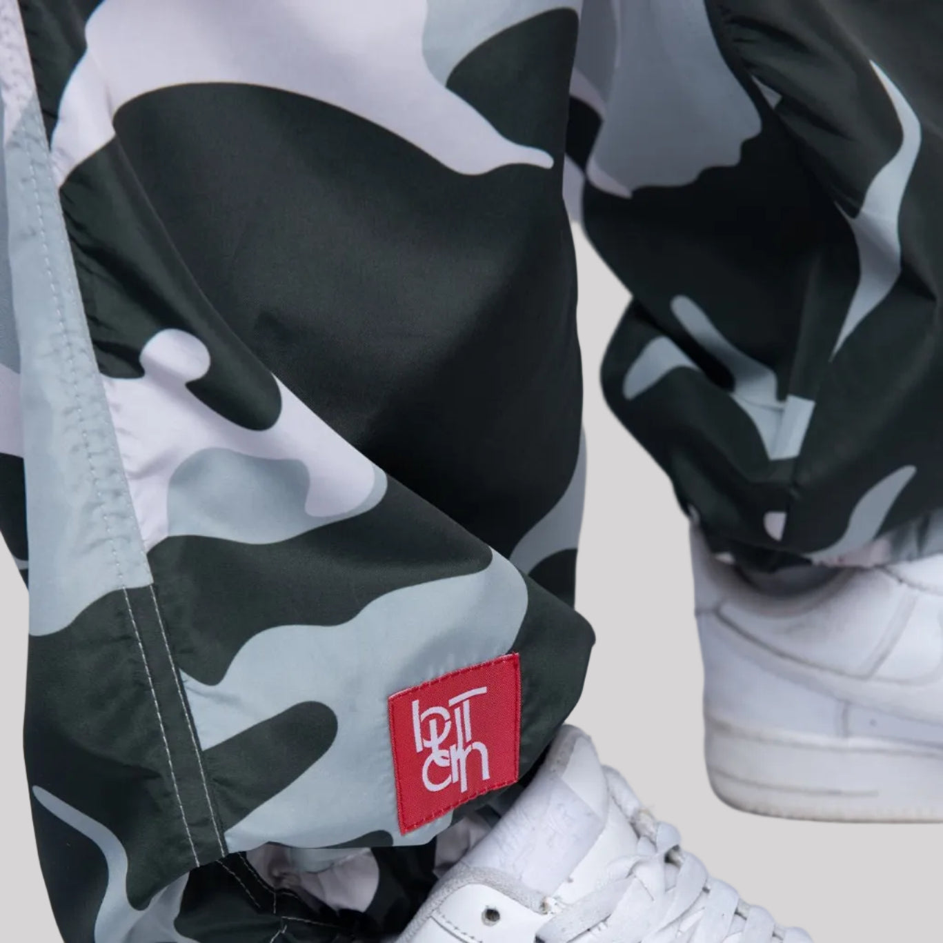 White sneaker with a red logo tag on a white background