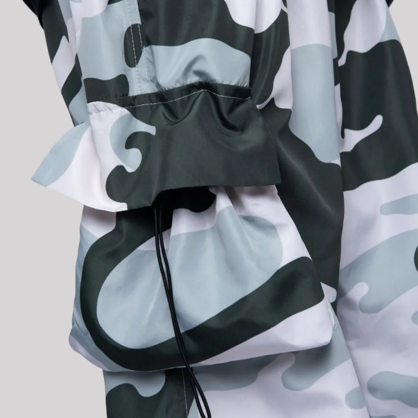 Camouflage-patterned jacket with a drawstring on a light gray background