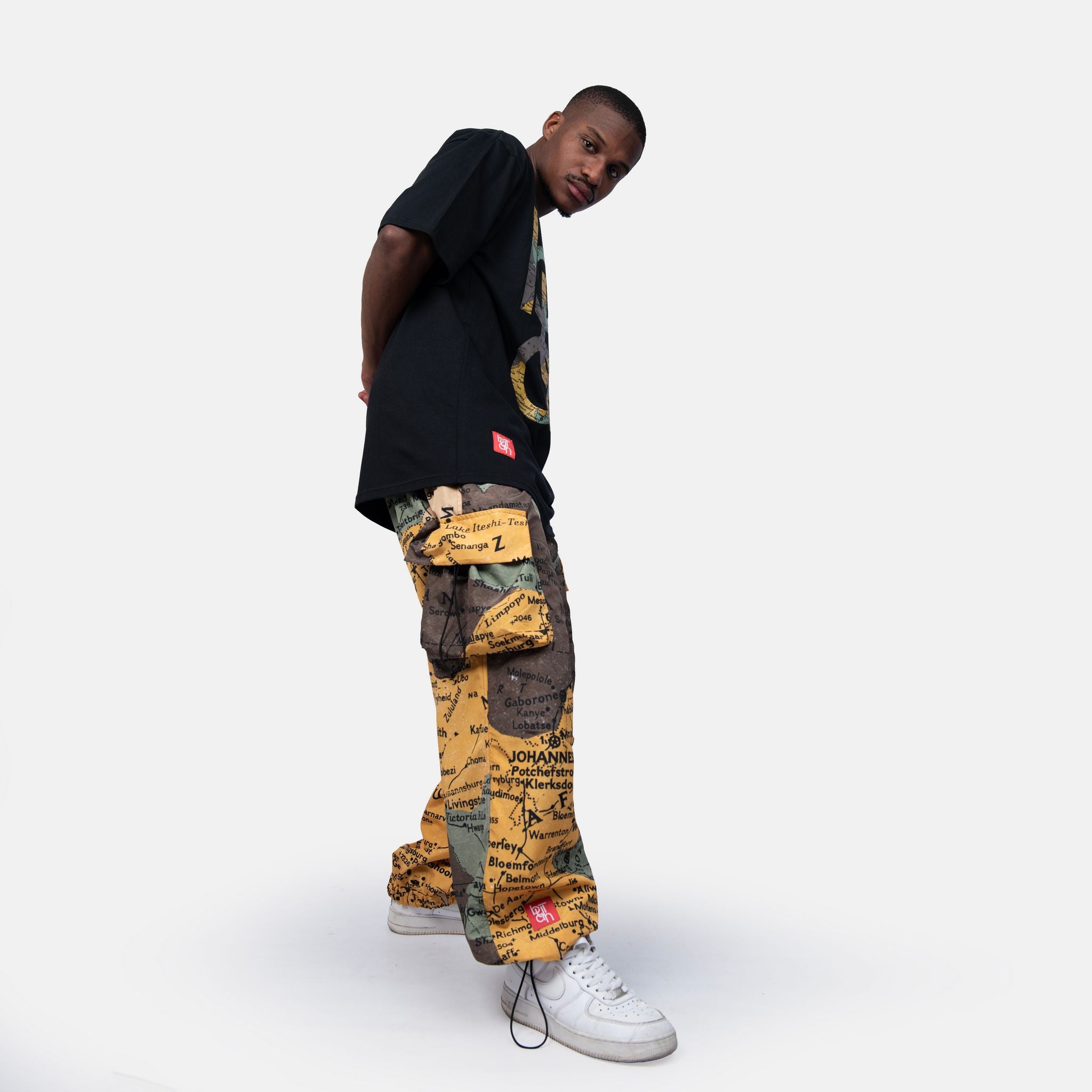 Person wearing a black shirt and colorful pants on a white background