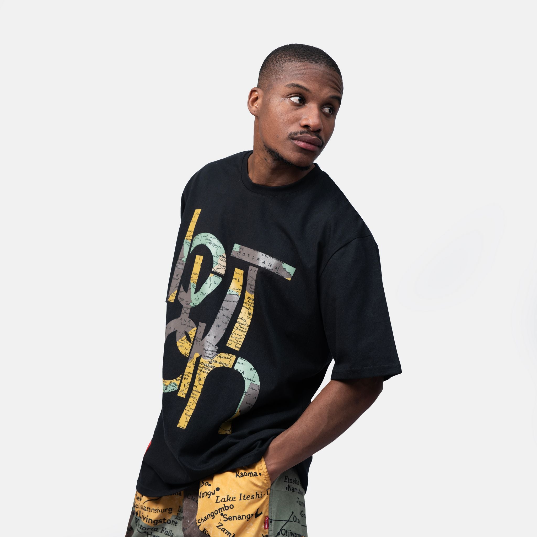 Man wearing a black t-shirt with colorful text design on a white background