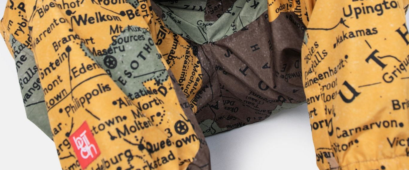 Person wearing patterned pants with text and a black shirt on a white background