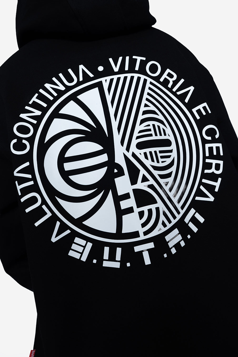 Close-up of the back of a black hoodie featuring a large white circular graphic print with stylized lettering and geometric patterns.