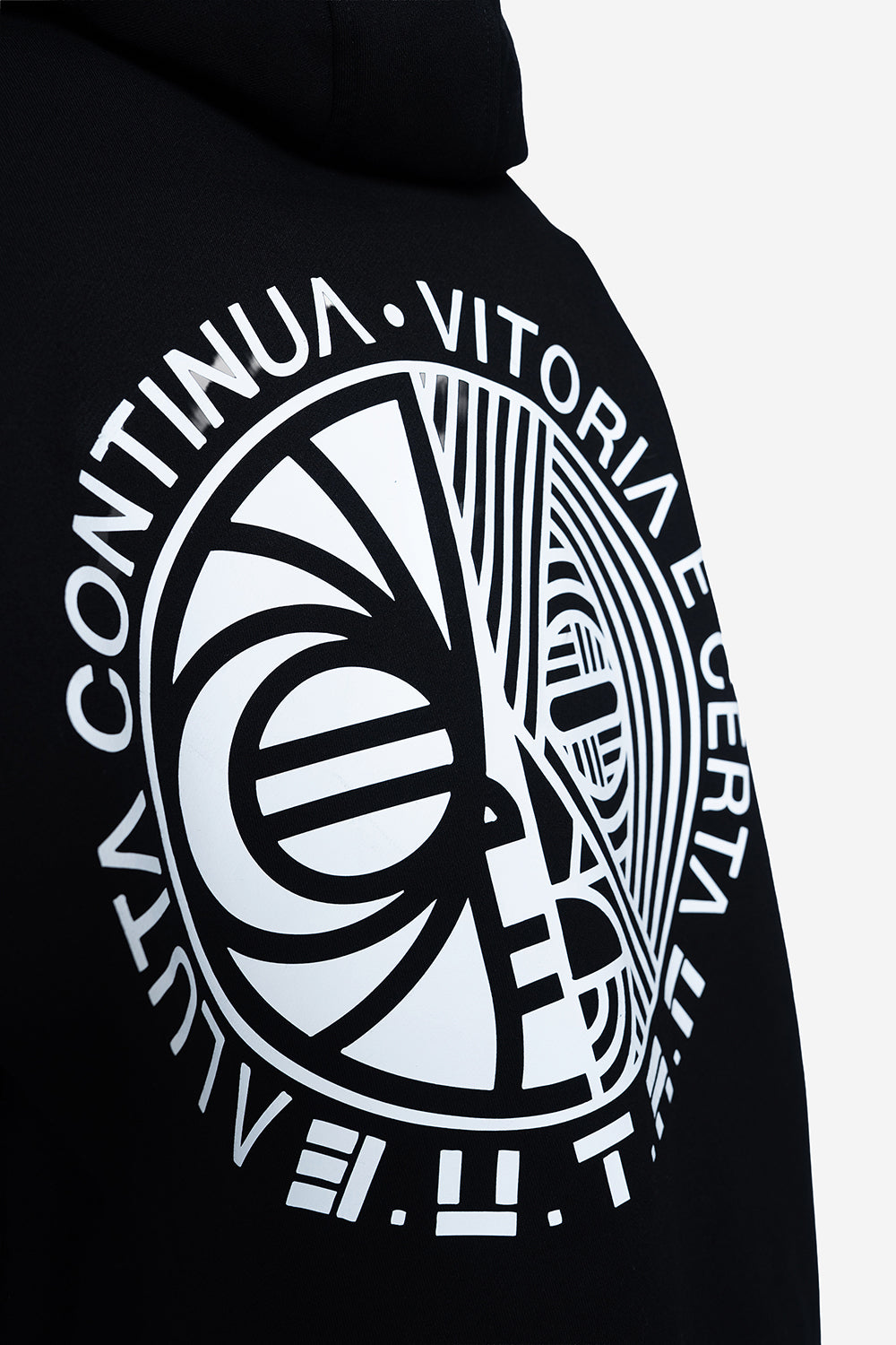 Close-up of a black hoodie featuring a large white graphic print on the back with circular text and abstract line art.